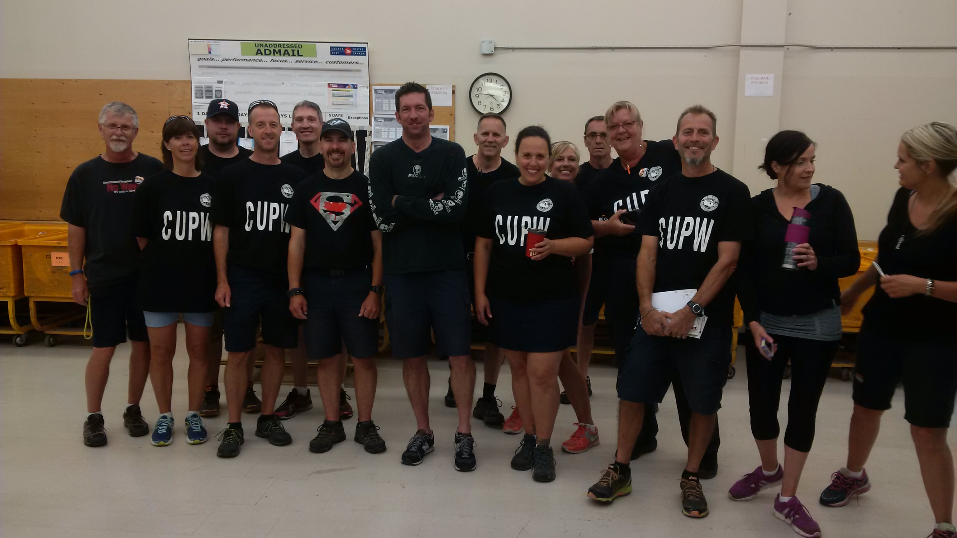 A group of postal workers in black t-shirts at a mail sorting plant A group of postal workers in black t-shirts at a mail sorting plant