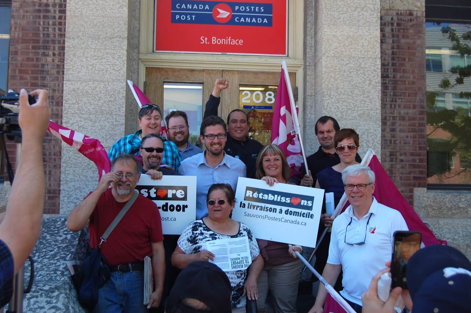 Group photo of people in front of St. Boniface post office with Group photo of people in front of St. Boniface post office with